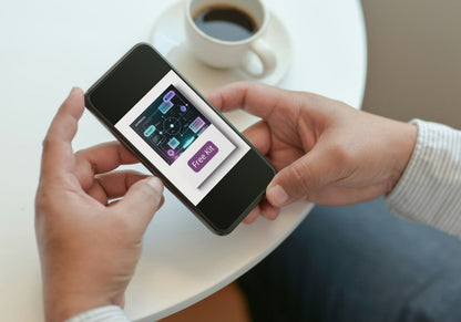 Person holding a smartphone with an app on the screen, next to a cup of coffee on a table.