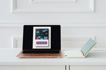 Laptop displaying a product image on a white surface with a book